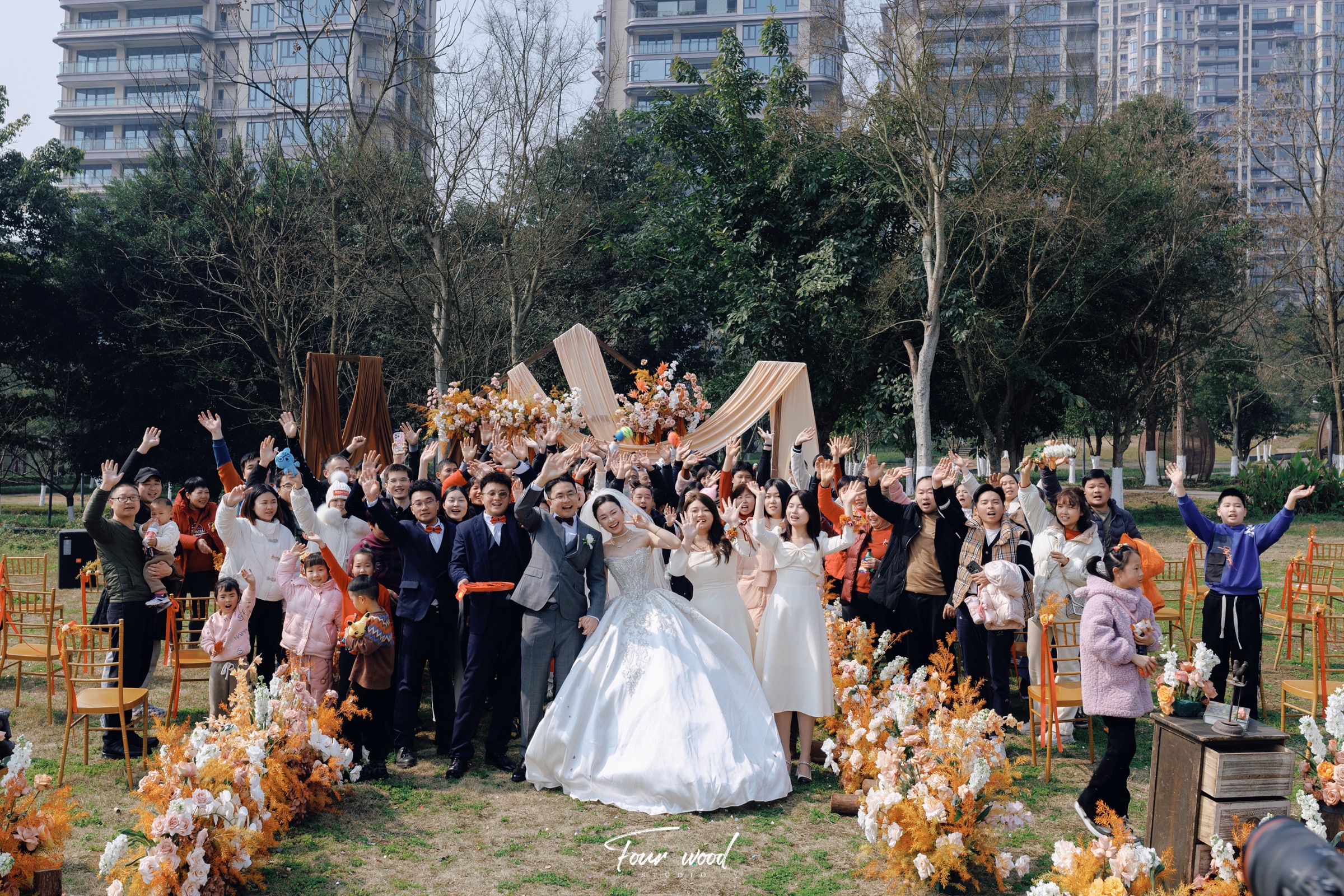 户外婚礼上新人和亲友们一起挥手合影